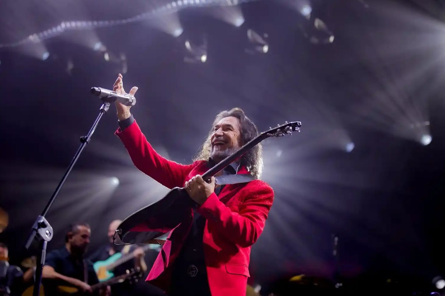 Marco Antonio Solís con traje rojo y guitarra durante una actuación; fotografía de Eduardo Cardoza difundida en el kit oficial de Tour Gratitud 2026.